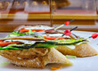 Appetizing spanish tapas with anchovies and green vegetables with wooden skewers on white tray closeup in Marbella, Costa del Sol, Spain
