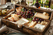 Cheese platter with different cheeses, grapes, nuts, honey, bread and dates in wooden craft box on dining table setting.