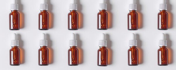 Wall Mural - Glass bottles with natural serum lie in a row on a white background.