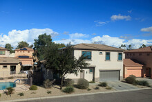 Arizona Typical Residential Neighborhood During Warm Winter Featuring Slowly Forming Cumulus Clouds Against Blue Sky