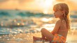 Curly-haired toddler in swimwear sits thoughtfully on the beach, with the sparkling ocean in the background.