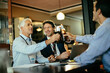 © Marko Geber - Businessmen toasting with beer after work at bar