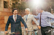 © Marko Geber - Businessmen with bicycles laughing together on city street
