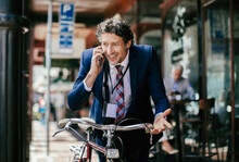 Businessman With Bicycle On Phone Call In City