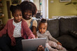 © Marko Geber - Mother and daughters using tablet together on the sofa at home