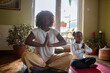 © Marko Geber - Young mother teaching her daughter how to do yoga and meditate at home