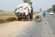 tractor with load broken down in the middle of the road