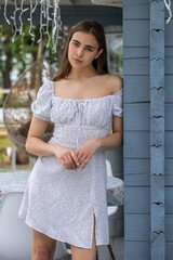 Wall Mural - Portrait of a young beautiful brunette woman in a white dress