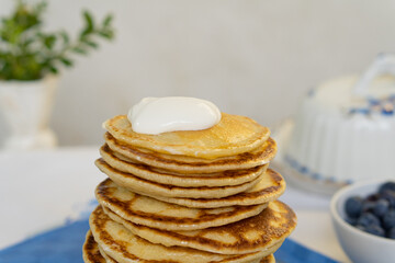 Wall Mural - Bright yellow pancakes on a blue napkin. Big stack of pancakes