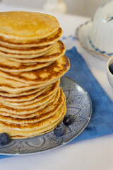 Wall Mural - Bright yellow pancakes on a blue napkin. Big stack of pancakes