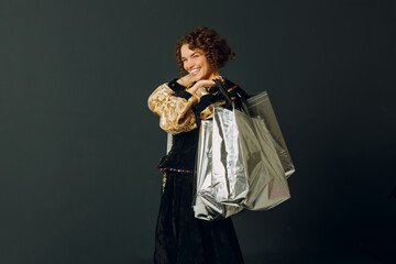 Wall Mural - Portrait of a young adult woman dressed in a medieval dress holding shopping bags in hands