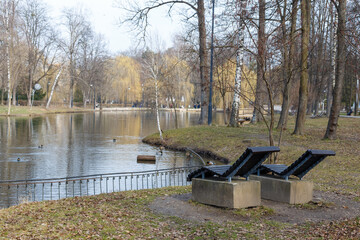 Two deck chairs overlooking a park near the lake.