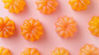 orange jelly desserts symmetrically placed on a pastel pink surface