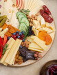 © nadyadudaeva - Cheese plate with many different snacks. Fruits, berries, crackers, honey, jam lie on the board.