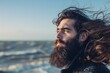 Long haired bearded man smiling in sea breeze