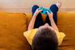 © ADDICTIVE STOCK - Child engrossed in video game play on sofa
