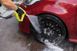 © ADDICTIVE STOCK - High-pressure washing of car tire and rim at auto detail
