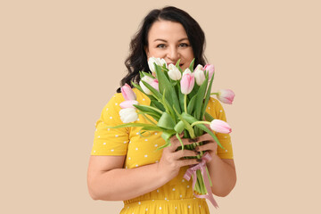 Wall Mural - Happy mature woman with bouquet of beautiful tulips on beige background. International Women's Day