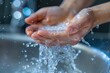 Water splashing from female hands, closeup of hands holding water