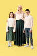 © Pixel-Shot - Happy Muslim mother with her children on yellow background. Eid al-Fitr celebration