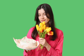 Poster - Beautiful young woman with sweet bento cake and bouquet of tulips on green background. International Women's Day