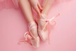 ballerina tying her shoes, top view, isolated on a pastel ballet pink background, symbolizing grace and preparation 