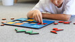 © Виктория Попова - A boy is playing a logical wooden game on the carpet. Montessori educational toys, geometric puzzle