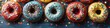 A row of colorful donuts with diverse toppings and sprinkles on a wooden background with scattered confetti, capturing the joy of sweet treats