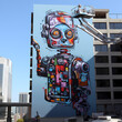 Robot painter creating a mural on a skyscraper
