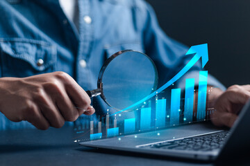 Businessman usu laptop to analyzing economic growth graph on virtual screen. Strategic planning for business growth and target customer group.