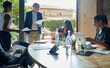 © Just images - Creative Team Collaboration in Modern Office. A diverse group of professionals engages in a collaborative discussion around a wooden table in a well-lit, contemporary office setting.