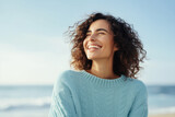 Fototapeta Uliczki - Joyful woman enjoying sunshine on sandy beach. Emotional wellbeing and relaxation.