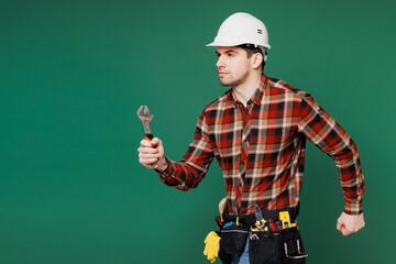 Sticker - Side view young laborer man wear red shirt hardhat hat work hold adjustable wrench run isolated on plain green background. Instruments accessories for renovation apartment room. Repair home concept.