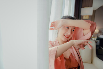 Asian teenage girl resting on the mattress After a full night's sleep And working in the morning in the bedroom. She is cheerful, bright, and happy.