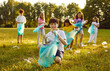 © Studio Romantic - Children volunteers collect garbage to make the area a nice place at a social charity ecology event Happy little school kids clean park ground from human waste that people throw not reaching trash bin