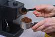 © Olena Vasylieva - women's hands pour coffee into the coffee machine
