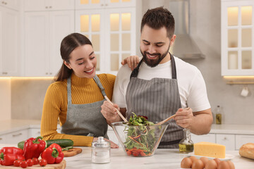 Poster - Lovely young couple cooking together in kitchen