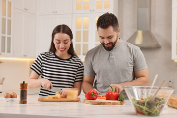 Wall Mural - Lovely young couple cooking together in kitchen