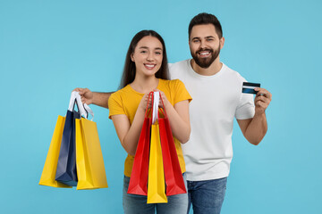 Sticker - Happy couple with shopping bags and credit card on light blue background