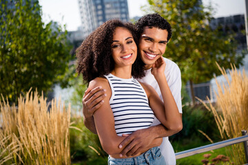 Poster - Photo of loving affectionate family couple husband cuddle his wife in central city park outside