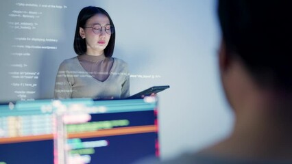 Wall Mural - a female software developer leads a tech discussion, her face lit by the projection of html code as 
