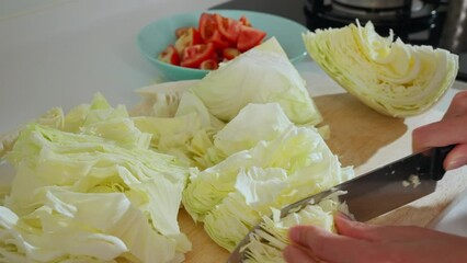 Canvas Print - Cutting cabbage with knife on the board at kitchen