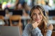 © Pinklife - A happy young woman enjoying her time working or studying with a laptop and headphones in a public space