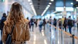 Image captures a woman from behind waiting in a busy airport check-in line