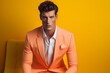 A dashing male model captivates in bright attire against a minimalist, solid-colored backdrop, exuding confidence and sophistication.