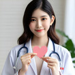 Front View of Female Doctor with Stethoscope Holding Pink Paper Heart