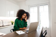 © Mia_Bon - An African American woman feeling exhausted while holding her left face working at home office in the morning