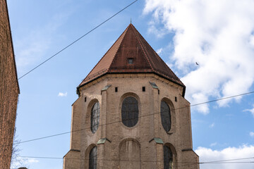 A tall building with a brown roof and a clock tower