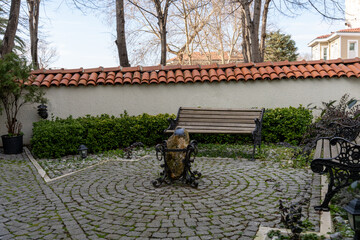 Wall Mural - A stone courtyard with a bench and a statue