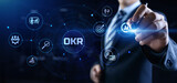 Fototapeta Konie - OKR Objectives key results. Businessman pressing button on screen.